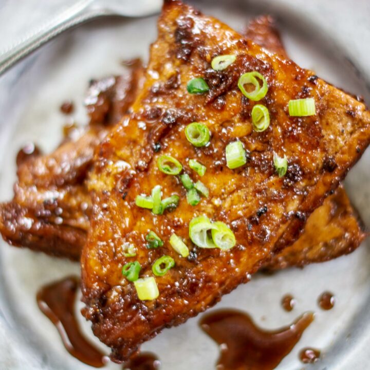 Silver-plate-with-glazed-salmon,-spring-onions-and-lemons